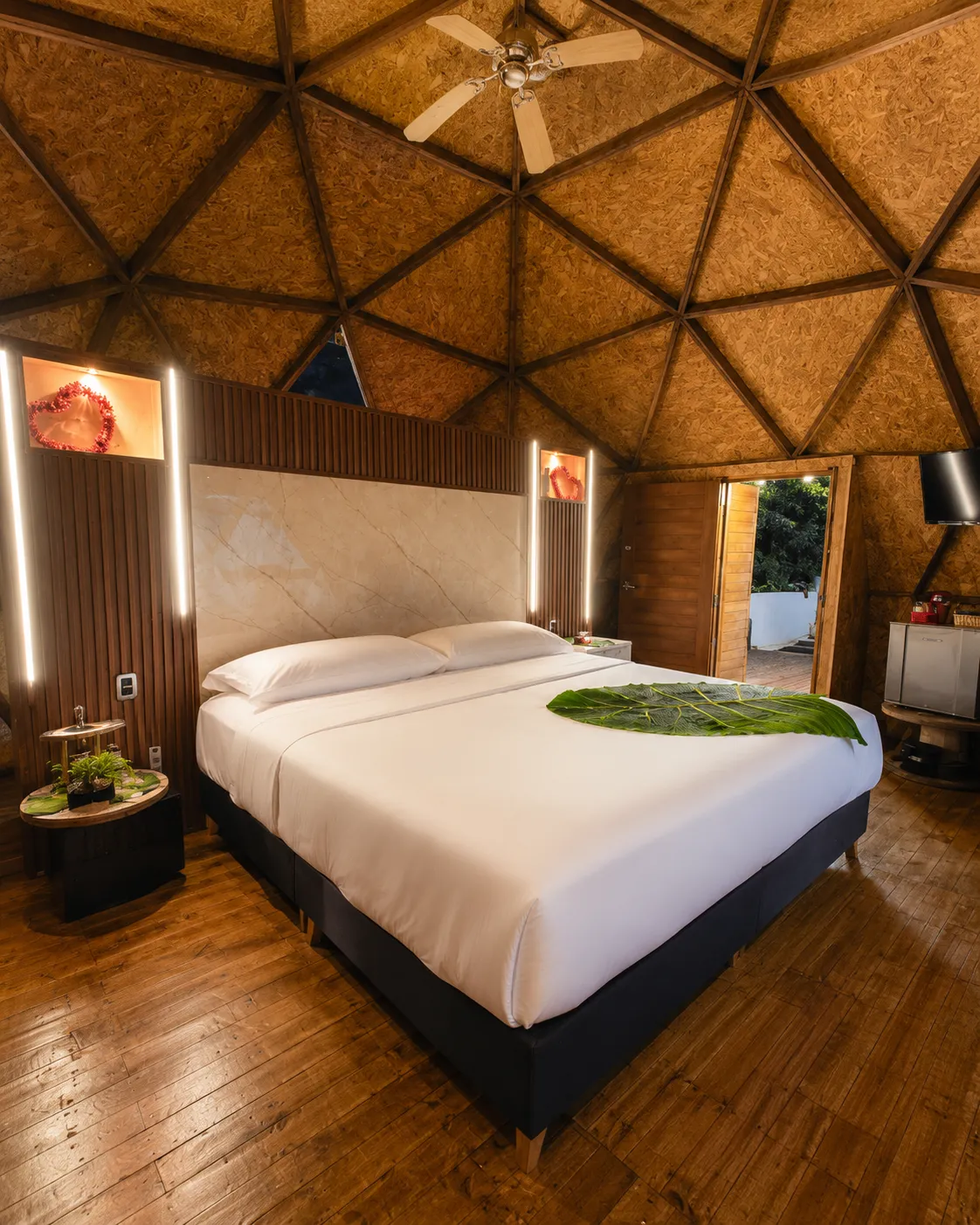 Interior cálido del domo con cama king y ventanal panorámico